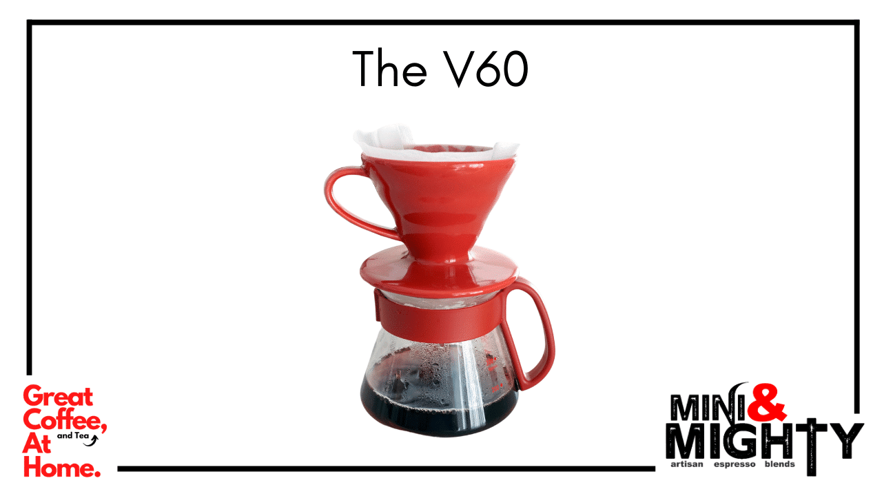 Hario V60 pour-over coffee brewing setup from Mini & Mighty Espresso, featuring a glass dripper with a spiral-ribbed design, placed atop a matching glass server, accompanied by a gooseneck kettle and digital scale—ideal for crafting precise, flavorful coffee at home.