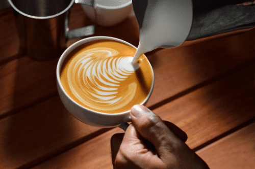 Barista preparing a latte with a professional espresso machine, showcasing expert technique and high-quality coffee preparation