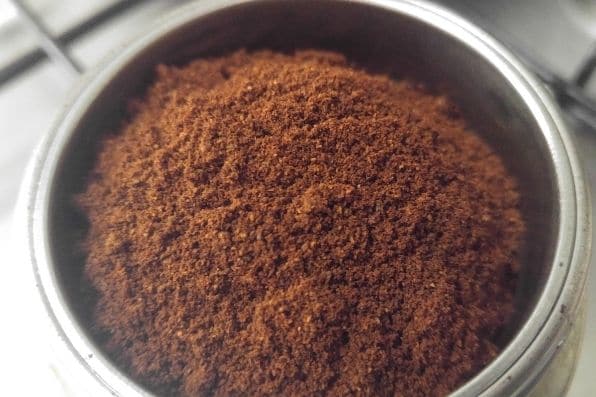 Close-up of fine ground coffee, ready for brewing with a professional espresso machine, showcasing quality preparation for espresso-based drinks