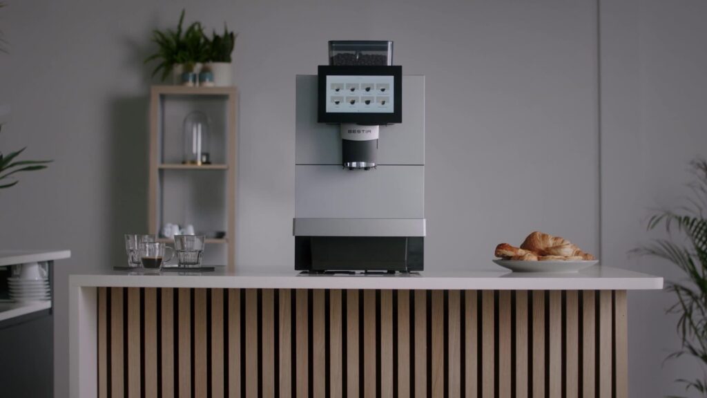 Bestir BM50 coffee machine on a stylish counter with touchscreen display, croissants, and espresso glasses — a premium model in the Bestir coffee machines range.