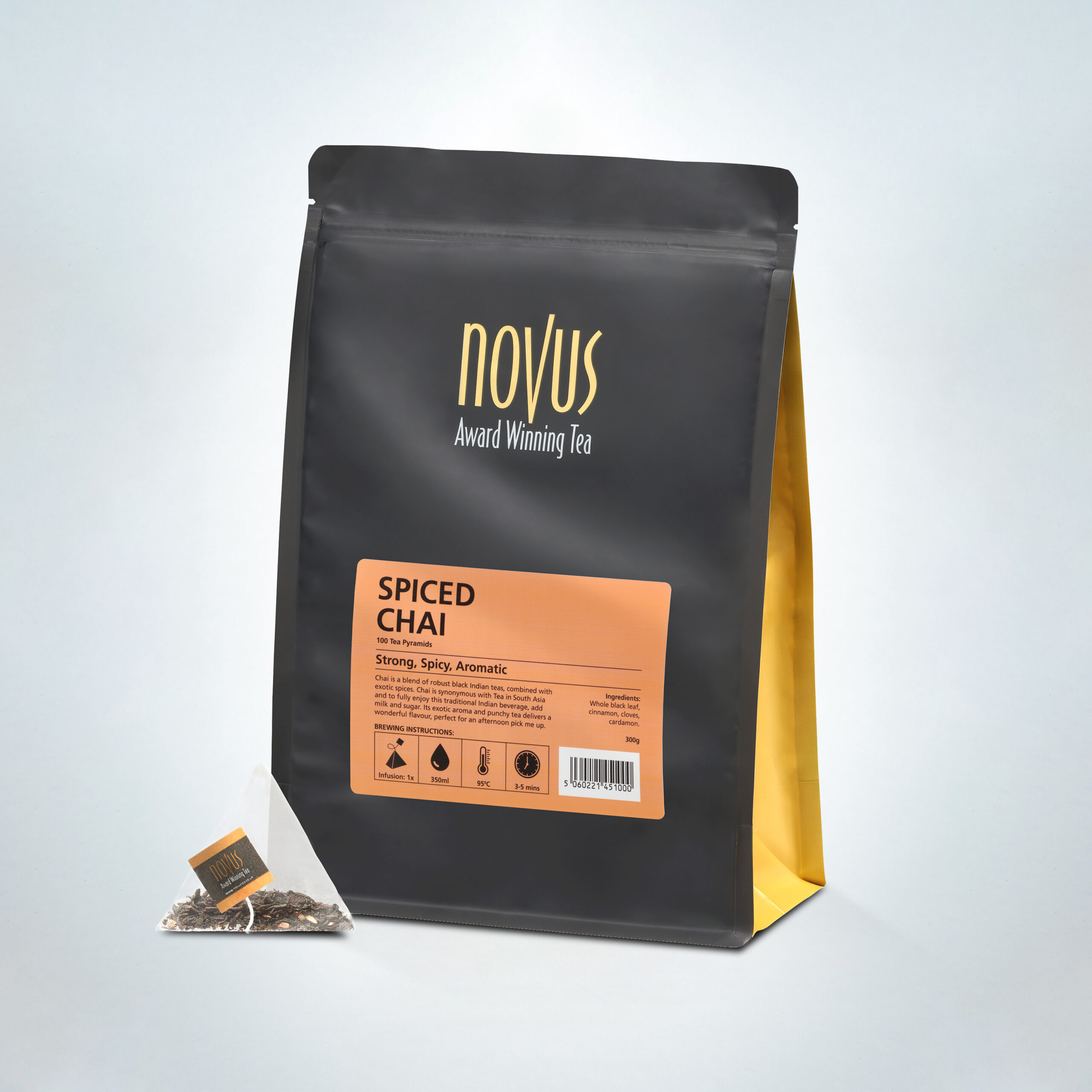 Novus Award Winning Spiced Chai Tea in a 100-pyramid bag pack, featuring a strong, spicy, and aromatic blend of black tea and warming spices, with a single pyramid tea bag beside the premium packaging