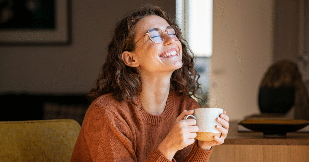 Happy woman enjoying a cup of coffee at home, representing the rise of home brewing in the UK coffee market 2025.
